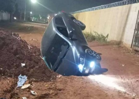 Carro cai em cratera aberta no meio da rua e dono amarga preju&iacute;zo