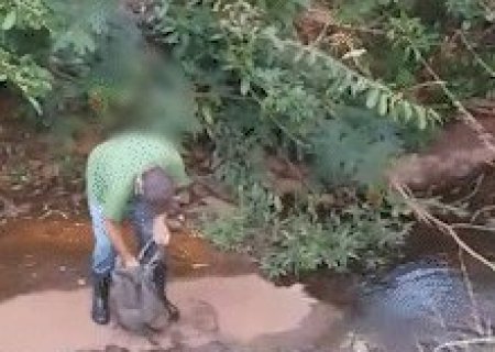 &Agrave; moda antiga e ao lado do shopping, homem pesca cascudo no C&oacute;rrego Prosa